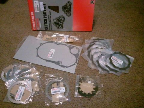 1995 Ford F-150 - A collection of motorcycle clutch plates and gaskets are spread out on a carpeted floor next to a Yamaha branded box.