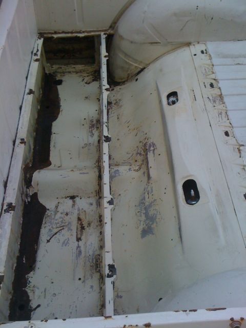 1964 Ford Ranchero - The interior of a truck bed shows extensive rust and wear.