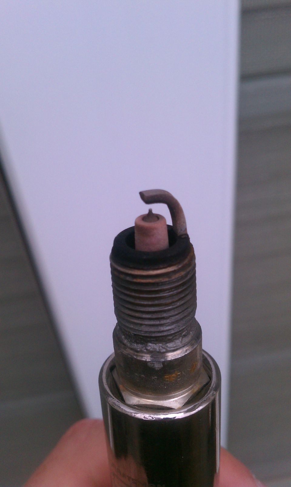 Close-up of a used spark plug with a bent electrode