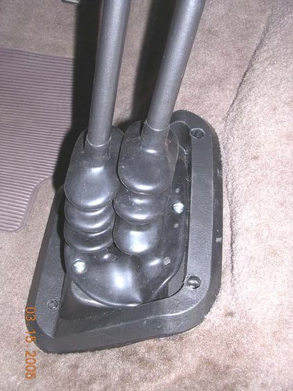 1982 Ford F-100 - Close-up of a dual stick shifter assembly, likely for a manual transmission, within a vehicle's interior cabin.