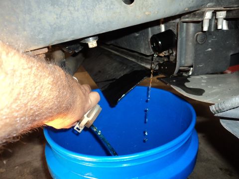 2004 Mercury Grand Marquis - Draining dark fluid from a vehicle into a blue bucket.