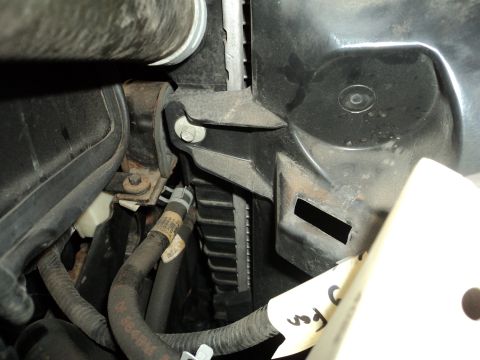 2004 Mercury Grand Marquis - Detail of hoses and a bracket near the radiator in a vehicle's engine compartment.