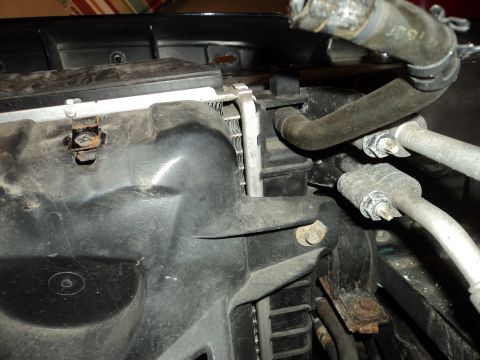 2004 Mercury Grand Marquis - Close-up view of a vehicle's radiator and coolant hoses, showing signs of age and corrosion.