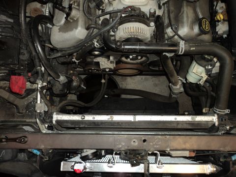 2004 Mercury Grand Marquis - Close-up view of a vehicle's engine bay, showing the radiator and alternator.