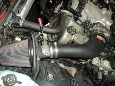 2004 Mercury Grand Marquis - Close-up of an engine bay a K&N air intake system and a screwdriver resting on a hose.