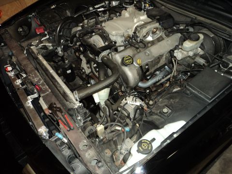2004 Mercury Grand Marquis - The engine bay of a car is shown, with various components and tools laid out.
