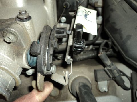 2004 Mercury Grand Marquis - Close-up view of a throttle body and its linkage mechanism, with a handwritten tag attached.