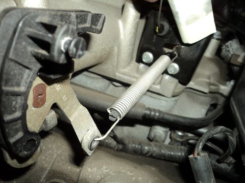 2004 Mercury Grand Marquis - Close-up of a throttle linkage spring and bracket assembly on an engine.