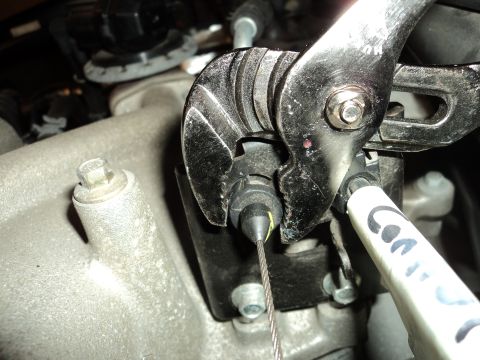 2004 Mercury Grand Marquis - Close-up of a wrench being used to adjust a throttle cable connection on an engine part.