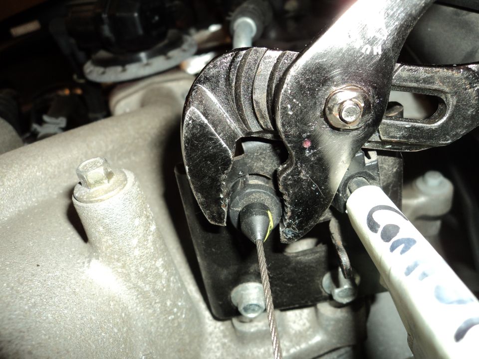 Wrench adjusting throttle cable on engine component