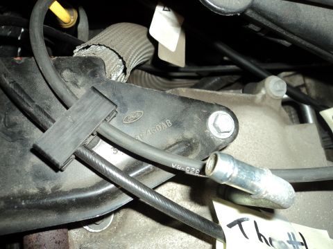 2004 Mercury Grand Marquis - A close-up view of a Ford engine component, showing some stamped lettering and a metal bracket.