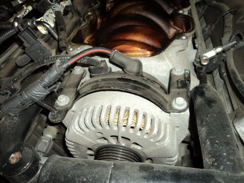2004 Mercury Grand Marquis - Close-up view of an alternator and associated engine components within a vehicle.