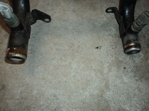 2004 Mercury Grand Marquis - Close-up view of two automotive coolant pipes, likely for a vehicle engine.