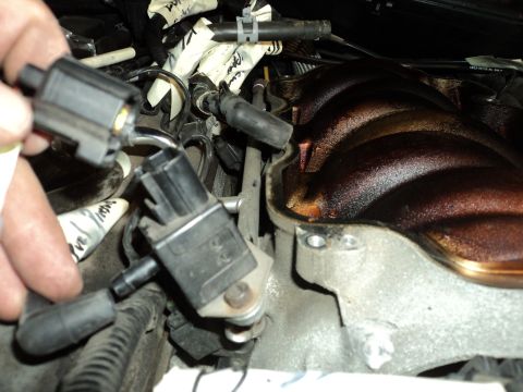 2004 Mercury Grand Marquis - Close-up view of engine components, showing sensors and wiring being disconnected from the intake manifold.