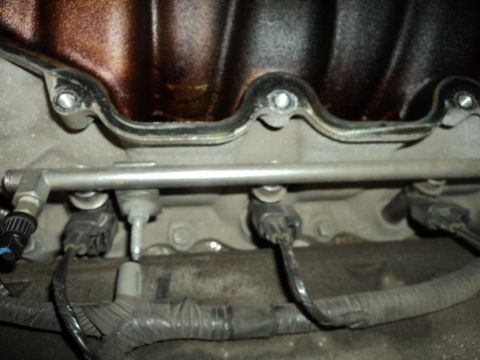 2004 Mercury Grand Marquis - Close-up view of fuel injectors connected to the fuel rail on an engine.
