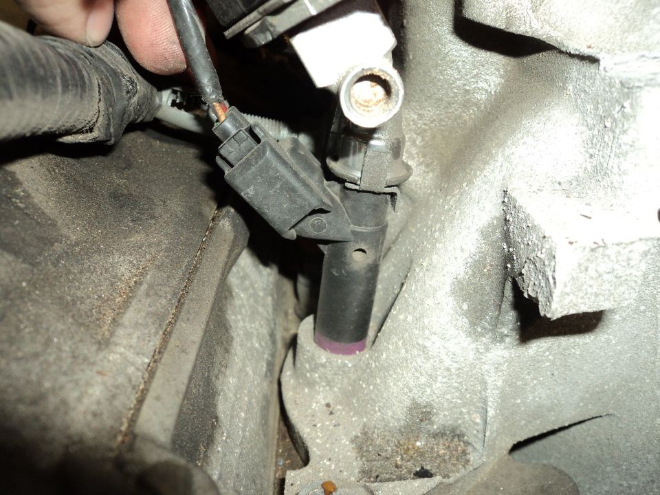 Engine part with purple marking and disconnected wiring harness