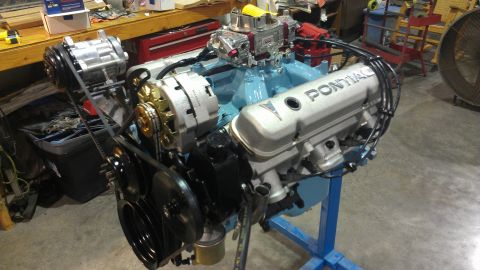 1972 Pontiac Trans Am - A Pontiac V8 engine assembly is shown on a stand in a workshop setting that appears to be a garage or workshop.