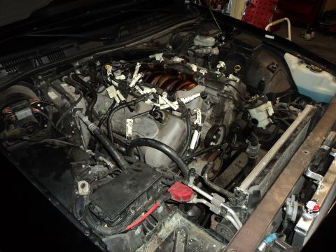 2004 Mercury Grand Marquis - The engine bay of a vehicle is shown with various components and wiring, suggesting ongoing work or repair.
