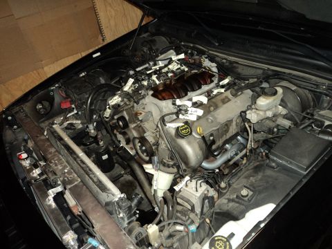 2004 Mercury Grand Marquis - Engine bay of a 2004 Mercury Grand Marquis, a supercharger and custom exhaust components.