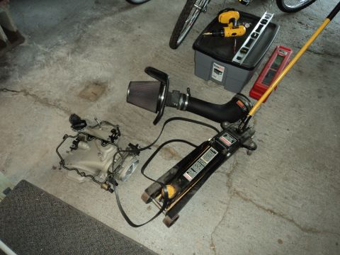 2004 Mercury Grand Marquis - Engine parts and tools are laid out on a garage floor, possibly for a vehicle repair or upgrade.