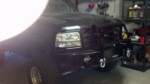 1995 Ford Bronco - Front view of a black 1995 Ford Bronco in a garage, showing custom bumper and grille.