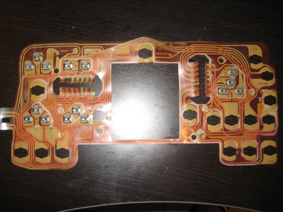 Circuit board with copper traces and multiple button contacts, likely from a vehicle's dashboard