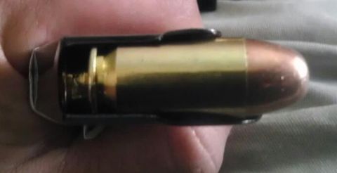 2000 Mercury Grand Marquis - A close-up view shows a single ammunition cartridge loaded into a magazine, held by a person's hand.