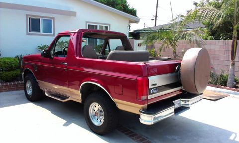 1994 Ford Bronco - Rear view of a red 1994 Ford Bronco with a tan two-tone paint scheme and a spare tire carrier.