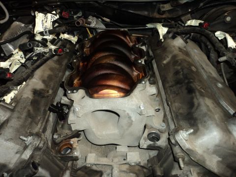 2004 Mercury Grand Marquis - Close-up view of an engine's intake manifold, showing oil buildup. The Supermotors.net watermark is present in the lower right corner.