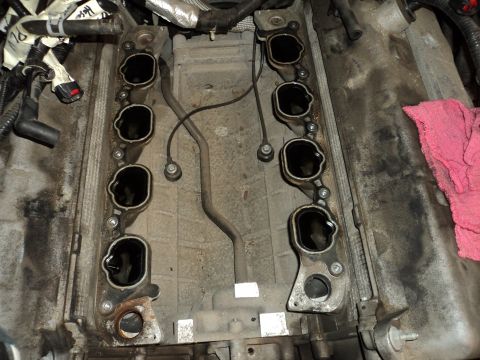2004 Mercury Grand Marquis - Close-up view of an engine's intake manifold with ports exposed, showing associated wiring and plumbing.