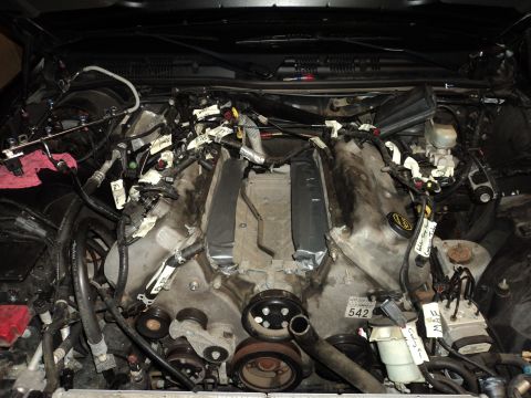 2004 Mercury Grand Marquis - Engine bay with V8 engine exposed, wiring harnesses labeled with tape for a project.