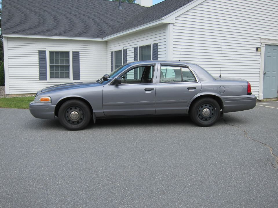 Gray 2001 Ford Crown Victoria sedan parked on asphalt, side view