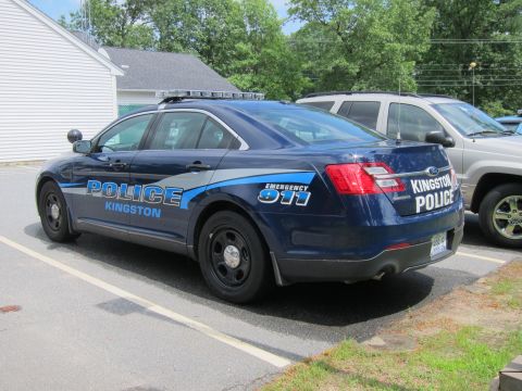 2001 Ford Crown Victoria - Kingston Police Interceptor parked in a lot, showing its rear quarter panel and markings.