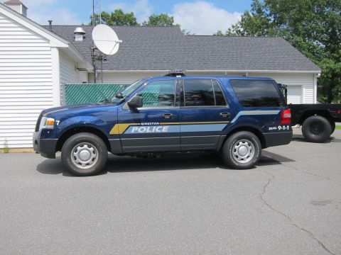 2001 Ford Crown Victoria - A Kingston Police SUV is parked outside a building with a satellite dish on the roof.