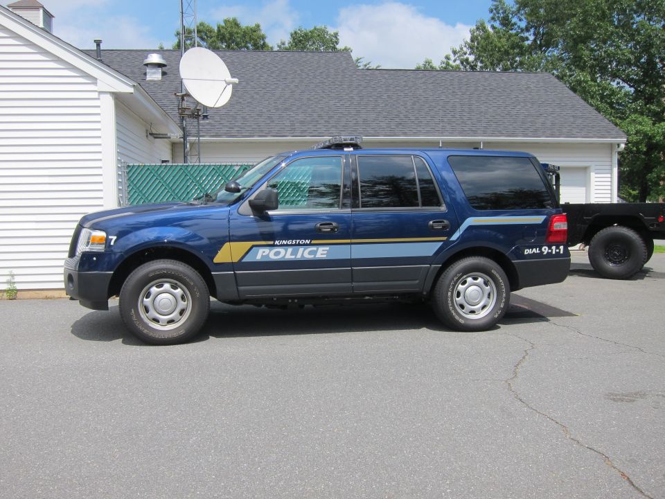 Blue police SUV with yellow and blue stripes on the side, marked 'KINGSTON POLICE'