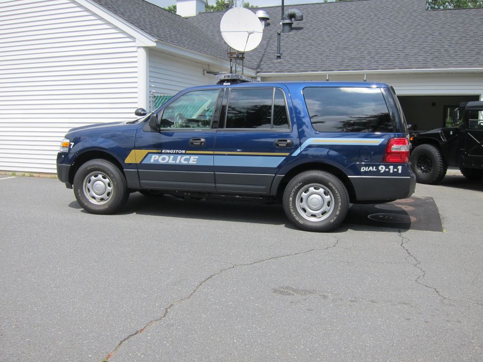 Blue police SUV with Kingston Police markings and a satellite dish on the roof