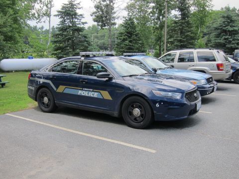 2001 Ford Crown Victoria - A 2001 Ford Crown Victoria police car is parked in a lot with other vehicles.