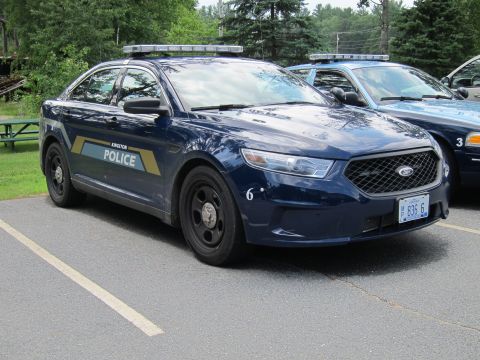 2001 Ford Crown Victoria - Two dark blue police cars are parked in a lot, one with 'Kingston Police' on the door.
