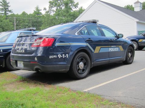 2001 Ford Crown Victoria - A dark blue police car with markings is parked next to another police car.