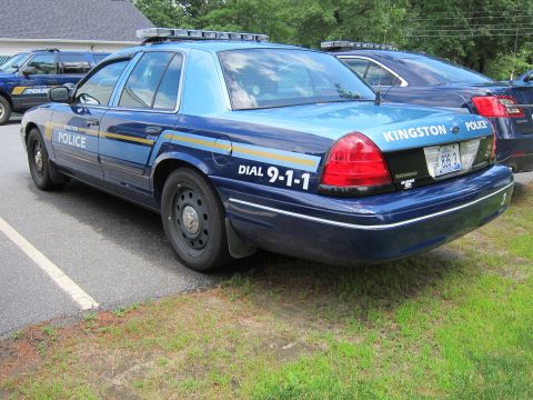 2001 Ford Crown Victoria - A Kingston Police car is parked next to another vehicle on a grassy area.