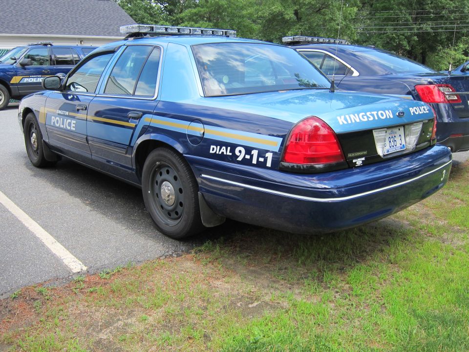 Police car with 'Kingston Police' and 'Dial 9-1-1' markings. License plate reads '836 3'