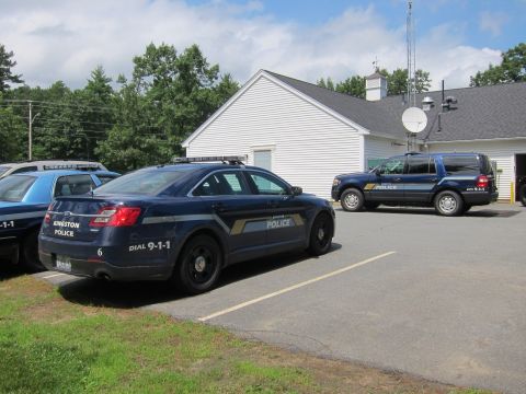 2001 Ford Crown Victoria - Two Kingston Police vehicles, a sedan and an SUV, are parked outside a building.