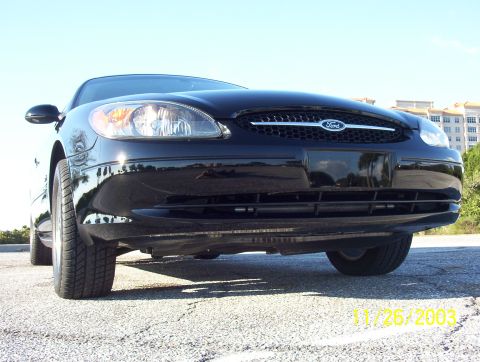 2003 Ford Taurus - A black Ford sedan is shown from a low front angle, with a date stamp indicating it was photographed in 2003.