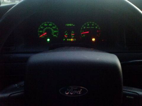 2008 Ford Crown Victoria - The illuminated dashboard displays the odometer reading and various warning lights.