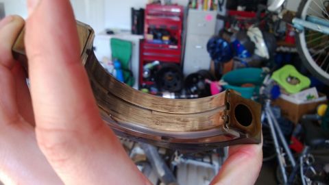 1994 Ford Bronco - Close-up of a used engine bearing, showing signs of wear and scoring.