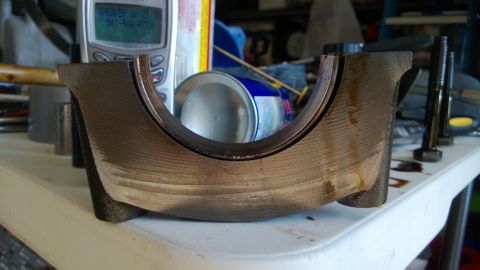 1994 Ford Bronco - A close-up view of a worn engine bearing, showing signs of significant use and potential damage.