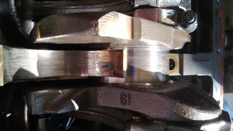 1994 Ford Bronco - Close-up of engine crankshaft and connecting rod bearings with visible wear and damage.