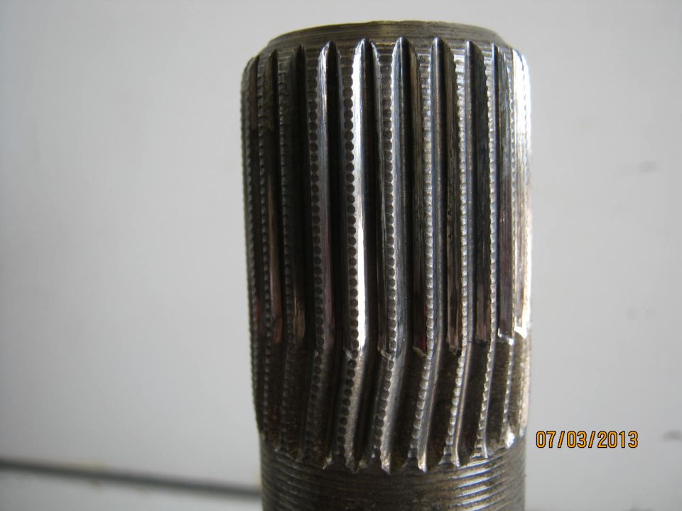 Close-up of a splined shaft end with a date stamp and website