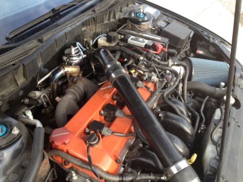 1987 Ford Bronco - The engine bay features an orange valve cover, a turbocharger, and a blue air filter, indicating performance modifications.