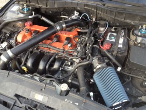 1987 Ford Bronco - The engine bay features aftermarket modifications including an upgraded air intake system and orange painted valve covers.